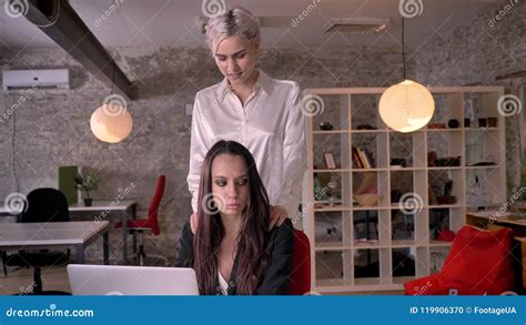 blonde lesbians|Young blonde lesbian massaging woman in modern office during。